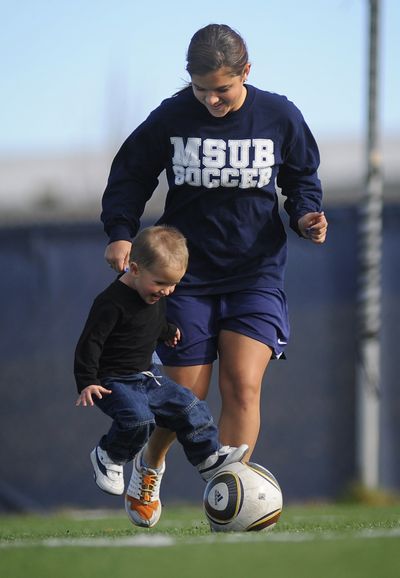 In this Nov. 1, 2010 photo, MSU-B soccer player Sami Sandau plays with her two-year-old son Koby before joining her team for soccer practice in Billings, Mont. (James Woodcock / The Gazette)