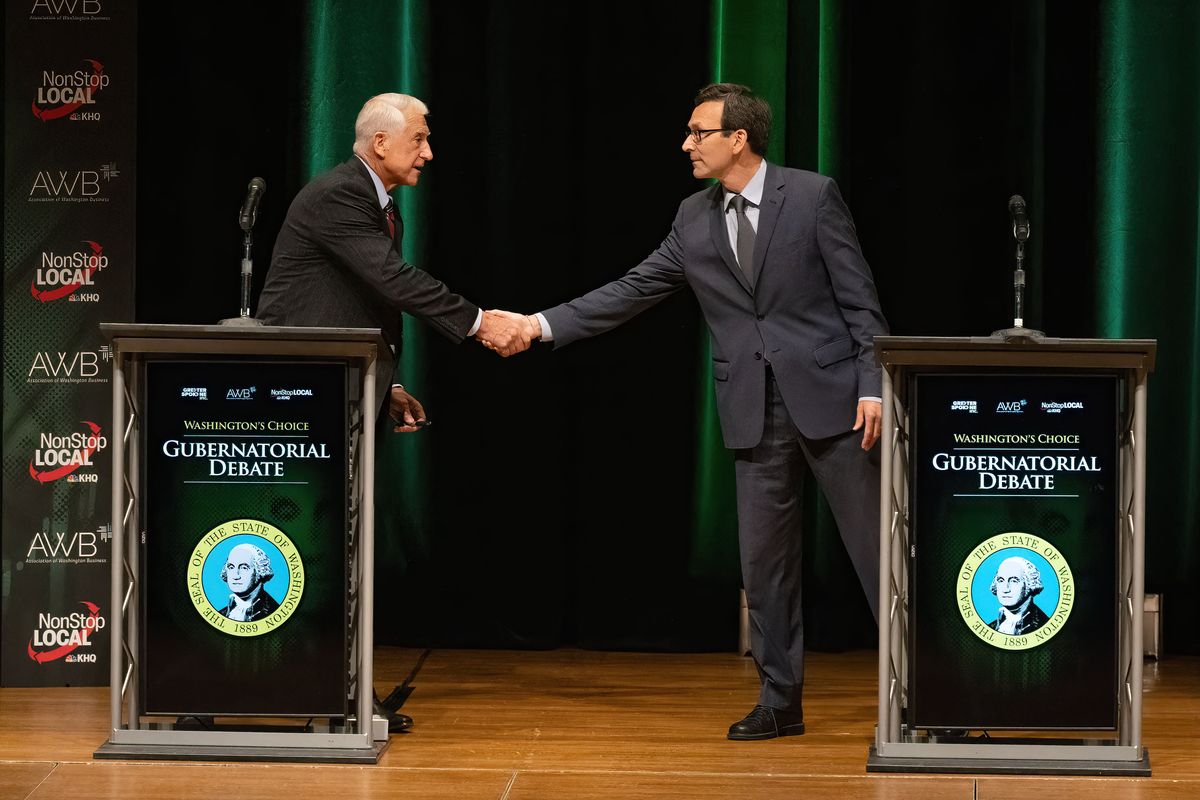 Candidates Dave Reichert, left, and Bob Ferguson shake hands after their debate Sept. 18 at the Martin Woldson Theater at the Fox.  (COLIN MULVANY/THE SPOKESMAN-REVIEW)