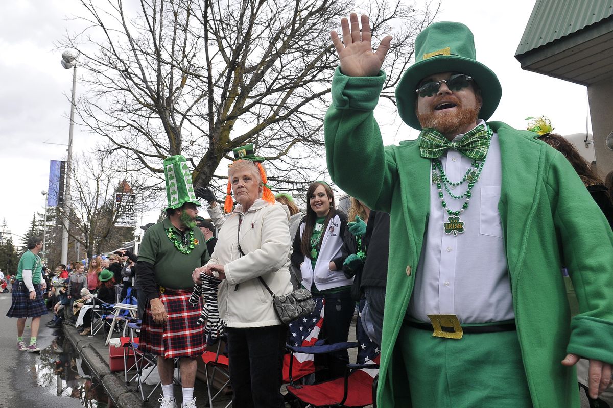 Chris Bell, right, waves from the sidewalk during the St. Patrick’s Day Parade on Saturday. (Jesse Tinsley)