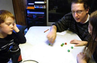 
Lawrence Torgersen plays a dice game with son Devin, 6, and daughter Tresa, 9, at his Spokane home recently. Torgersen took a class aimed at teaching fathers how to nurture their children. 
 (Holly Pickett / The Spokesman-Review)
