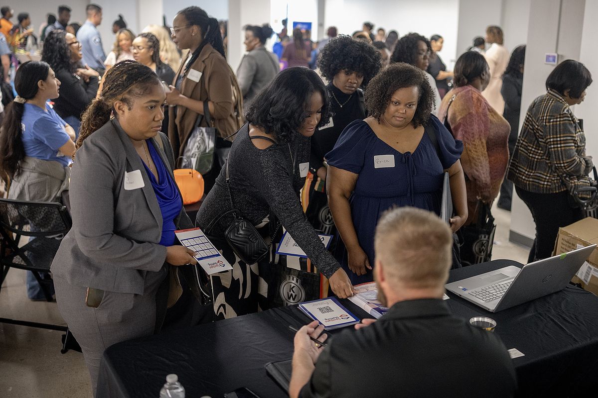Erica Swain, center, joins others to listen to a job fair vendor during a job fair for Black women at The Coliseum in Minneapolis on Friday, Oct. 17, 2025.   (Elizabeth Flores/The Minnesota Star Tribune/TNS)