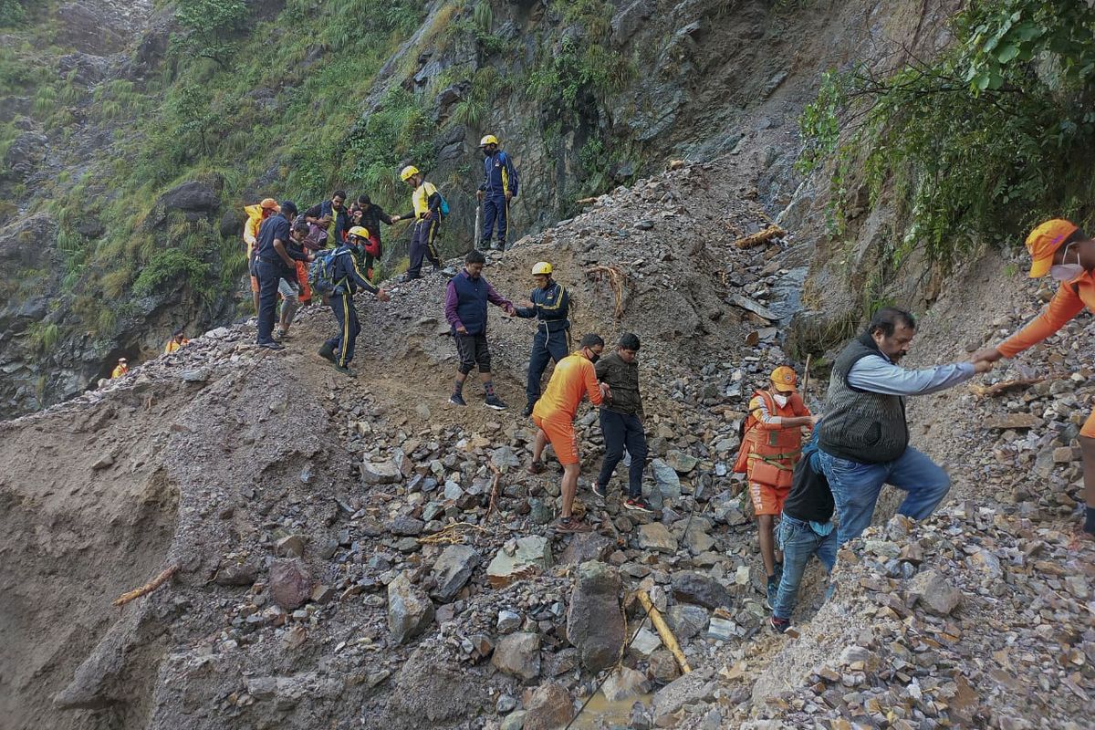 This photograph provided by India’s National Disaster Response Force (NDRF) shows NDRF personnel rescuing civilians stranded following heavy rains at Chhara village near Nainital, Uttarakhand, Wednesday, Oct. 20, 2021. Nainital remained cut off from the rest of the state as roads leading to it were either blocked by landslides or washed away.  (HONS)