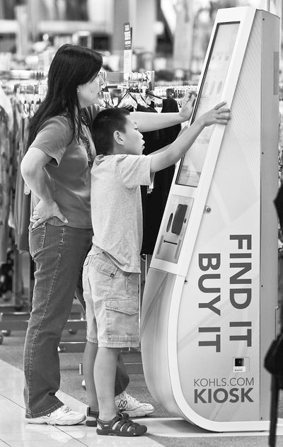 Lily Kozai and her son, Kobi Kozai, 10, use a kiosk installed at a Kohls store in Torrance, Calif., for shoppers to go online to locate and order items not available at the brick-and-mortar location. 