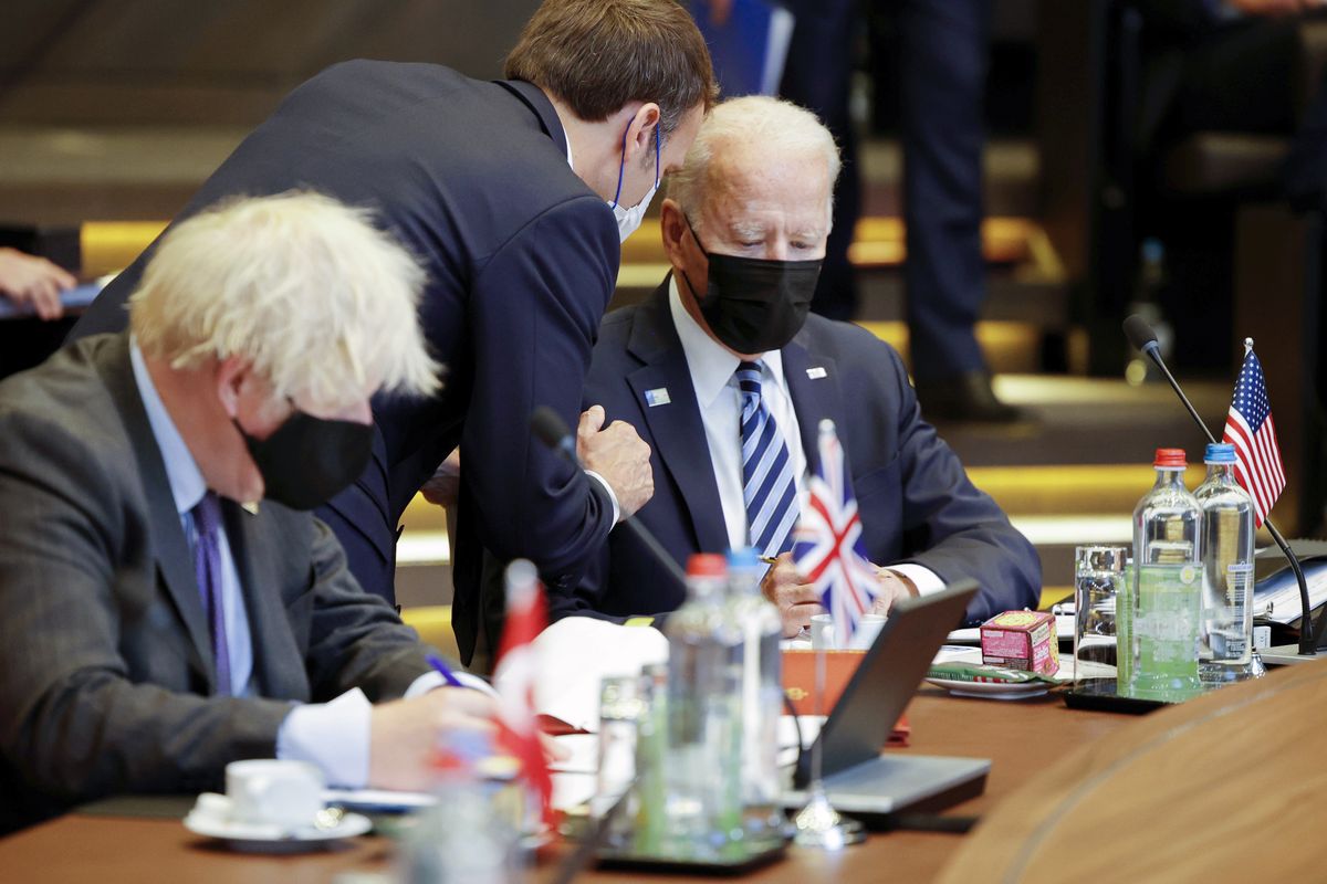 FILE - In this June 14, 2021, file photo French President Emmanuel Macron, center, speaks with U.S. President Joe Biden, right, during a plenary session at a NATO summit in Brussels. Ties between the United States and its oldest ally, France, have long been fraternal, but they
