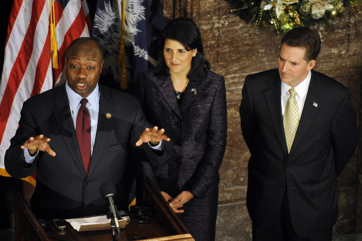 U.S. Rep. Tim Scott, left, speaks during a news conference as South Carolina Gov. Nikki Haley and Sen. Jim DeMint look on at the Statehouse on Monday, Dec. 17, 2012, in Columbia, S.C. Scott was named as DeMint