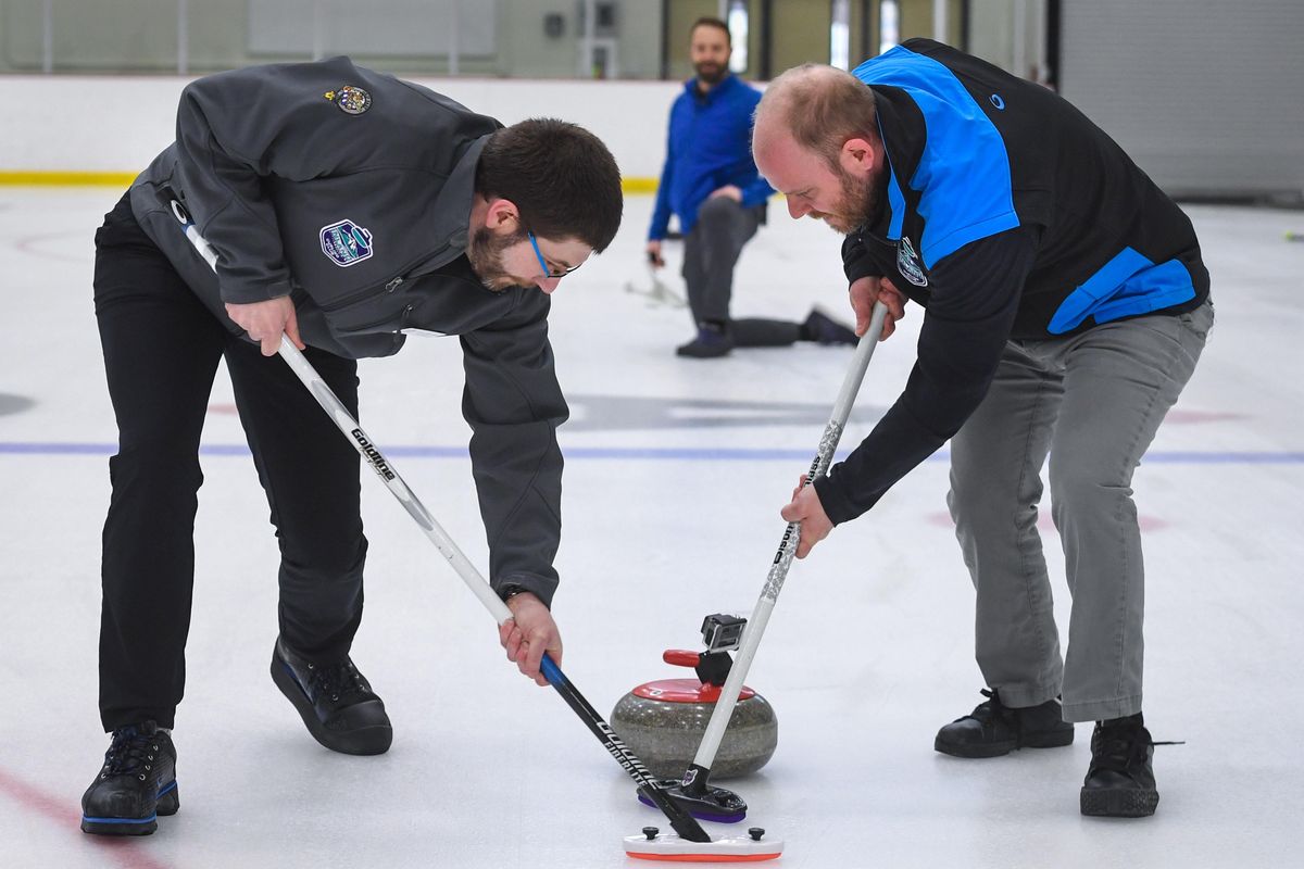 Matt Moore, left, and George Thomsen sweep the ice in front of a granite curling stone during a demonstration, Wednesday, Jan. 29, 2020, at the EWU Recreation Center in Cheney, Wash. (Dan Pelle / The Spokesman-Review)
