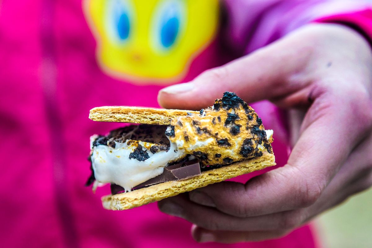 Julianna Schwam holds a s’more that she made using her invention, the Safe S’Mores Shield in front of her home in Coeur d’Alene on Wednesday, Jan 18, 2023. The 5th grader’s invention won Invent Idaho’s Award:Best Logbook Award at Invention Convention U.S. Nationals.  (Kathy Plonka/The Spokesman-Review)