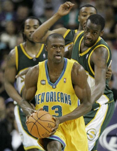 
Hornets' Linton Johnson looks to pass Friday night as he is trailed by a trio of SuperSonics, from left: Chris Wilcox, Rashard Lewis and Johan Petro.
 (Associated Press / The Spokesman-Review)