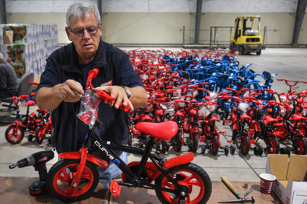 Volunteer Greg Fong assembles children’s bicycles for the Spokesman-Review Christmas Bureau, Wednesday, Dec. 10, 2019, at the Spokane County Fair & Expo Center. (Dan Pelle / The Spokesman-Review)