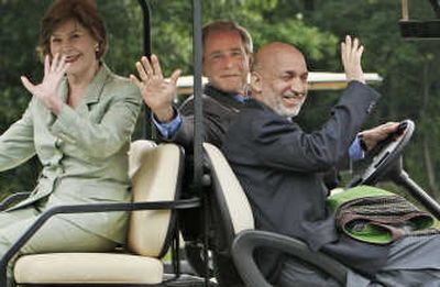 
President Bush drives Afghan President Hamid Karzai and first lady Laura Bush in a golf cart  Sunday. Associated Press
 (Associated Press / The Spokesman-Review)