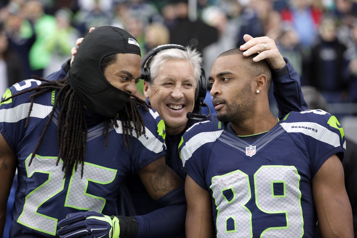 Seahawks head coach Pete Carroll is obviously glad two of his stars, Richard Sherman, left, and Doug Baldwin, have decided Seattle is where they like to play. (Associated Press)