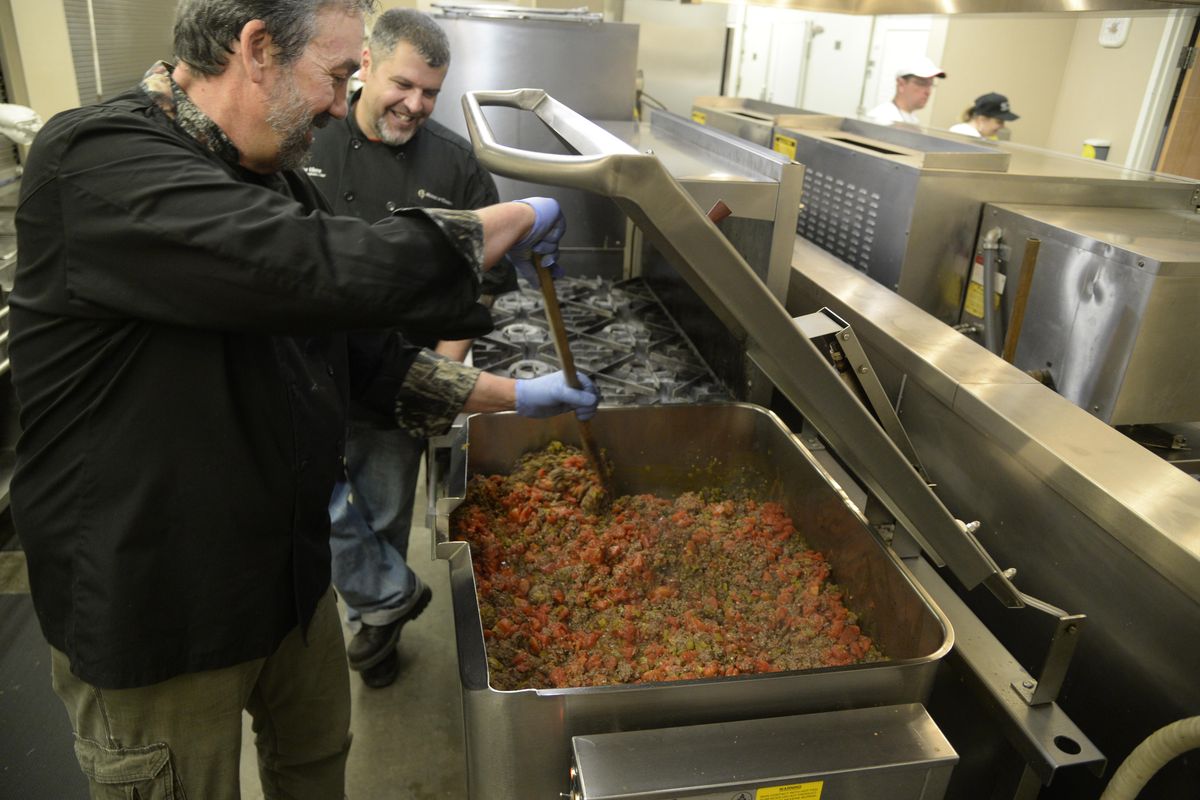 TV chef Scott Leysath, left, stirs the first ingredients of venison chili while chatting with Steve Viers, food services coordinator and chef at the House of Charity. Leysath, featured on a cable show called “The Sporting Chef,” held a wild game chili feed at the HOC to promote the use of game meat to feed the needy. (JESSE TINSLEY jesset@spokesman.com)