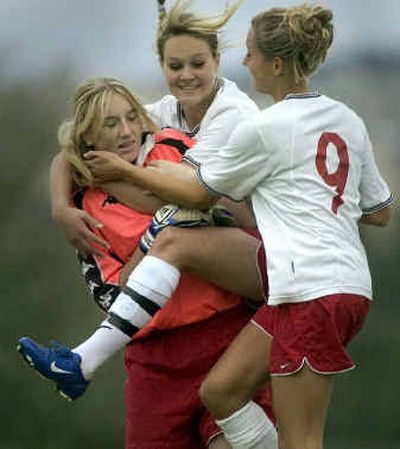 
After winning their sudden-death soccer match against Gonzaga Prep, Ferris teammates Liz Boyden, far left, her sister Hillary Boyden, center, and Brooke Lafleur celebrate Wednesday at Ferris.
 (Colin Mulvany / The Spokesman-Review)