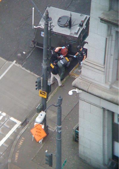 Police detain a man wearing what appeared to be a pipe bomb after he was kicked out of a Seattle homeless shelter Friday morning.  (Associated Press)
