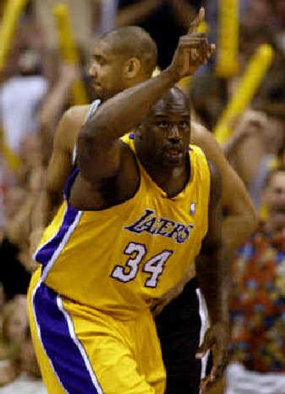
Los Angeles center Shaquille O'Neal reacts after making a shot as San Antonio's Tim Duncan looks away.
 (Associated Press / The Spokesman-Review)