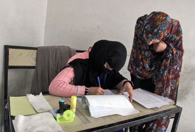 An Afghan election worker, left, registers a woman at the voter registration office in Kandahar province on Thursday.  (Associated Press / The Spokesman-Review)