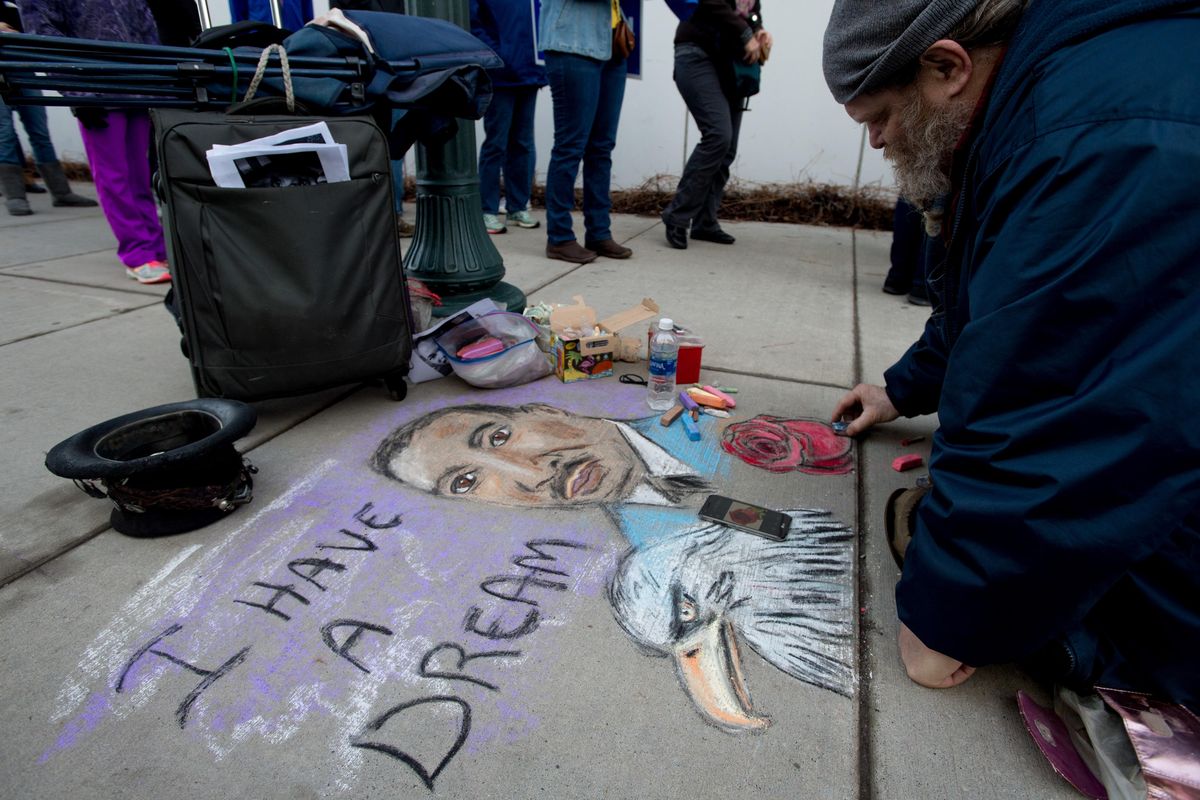 Local artist Rick Bocock works on a chalk rendering of Dr. Martin Luther King Jr. before the start of the annual Unity March in celebration of Martin Luther King Jr. Day on Monday, Jan. 15, 2018, outside the Spokane Convention Center in Spokane, Wash. (Tyler Tjomsland / The Spokesman-Review)