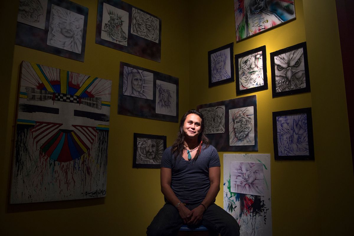 Jacob Johns poses for a photo with a selection of his artwork on Dec. 3, 2015, at McCarthy Art Company in Spokane.  (TYLER TJOMSLAND/THE SPOKESMAN-REVIEW)