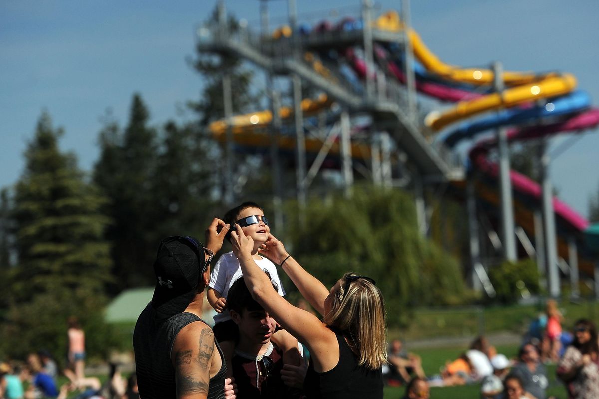 “He loves the moon right now,” said Lacey Nardone as she and her husband, Mario, held the eclipse glasses on her 2-year-old son Vincent while he was on his uncle Noah Rodal’s shoulders at Silverwood Theme Park in Athol on Monday, August 21, 2017. The family is from Seattle and planned a trip to Silverwood. (Kathy Plonka / The Spokesman-Review)