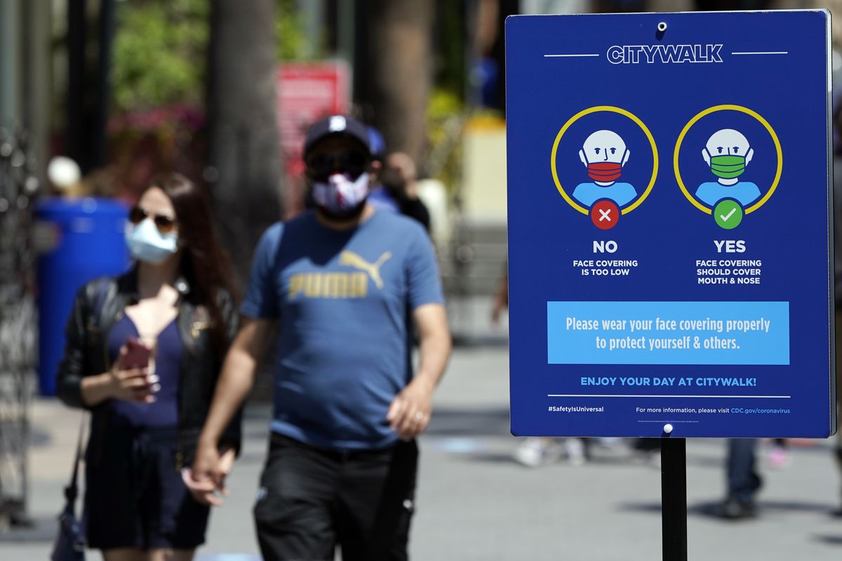 Signs instruct visitors on the proper way to wear masks at the Universal City Walk on May 14 in Universal City, Calif.  (Marcio Jose Sanchez)