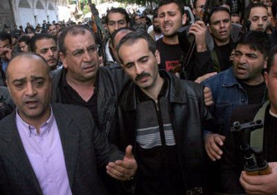 
Palestinian senior intelligence officer Baha Balousheh, center, is comforted during the funeral for three of his sons, who were killed in a drive-by shooting Monday in Gaza City, Gaza Strip. 
 (Associated Press / The Spokesman-Review)