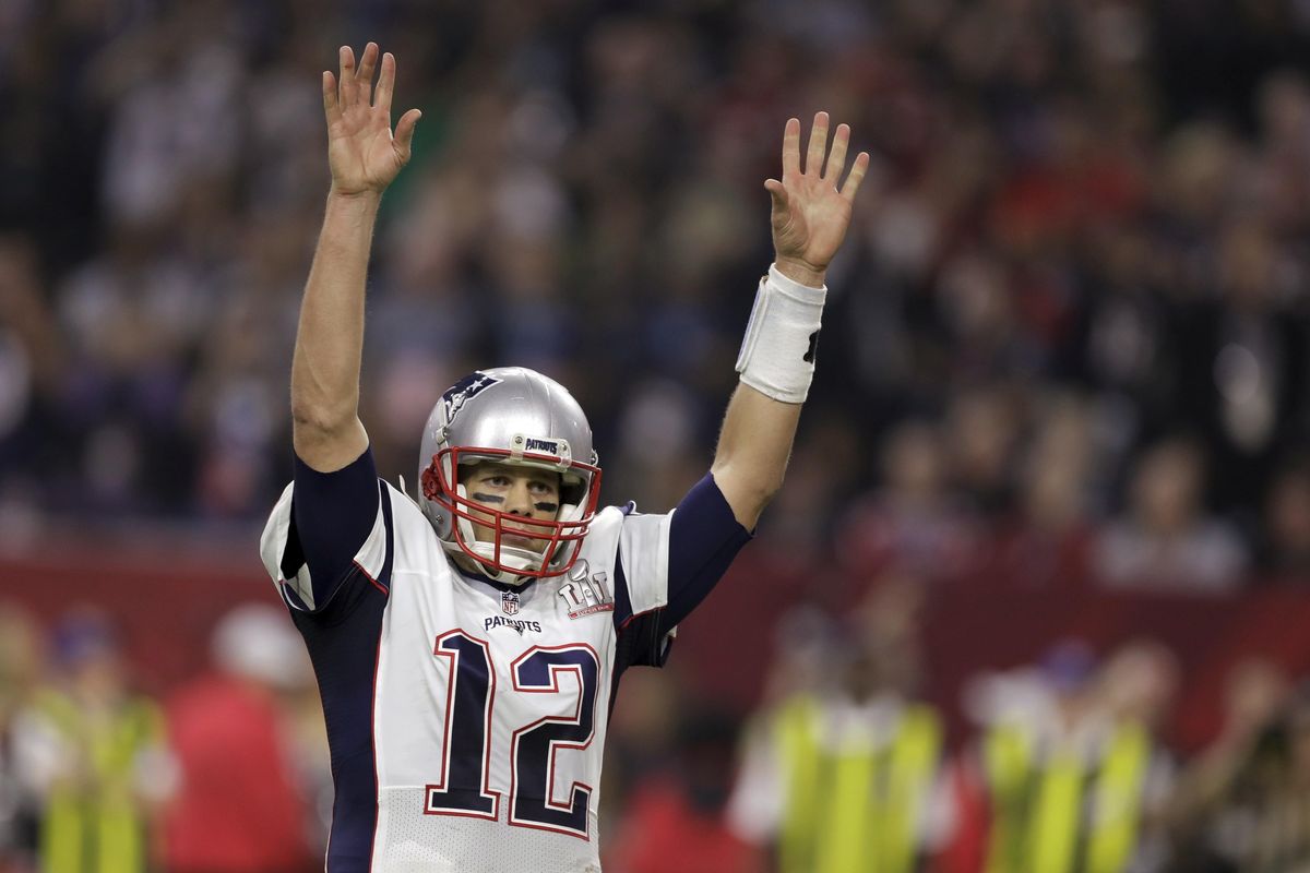 New England Patriots quarterback Tom Brady raises his arms after his team scored a touchdown during overtime. (Darron Cummings / Associated Press)