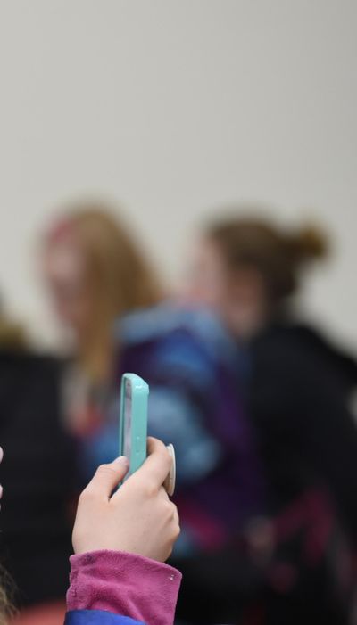 THIS PICTURE IS CROPPED LIKE THIS BECAUSE THE PARENT OF EVERY KID THAT I PHOTOGRPHED SAID NO.----- A student at Canfield Middle School uses her cell phone before the start of classes on Wednesday, March 14, 2017. (Kathy Plonka / The Spokesman-Review)