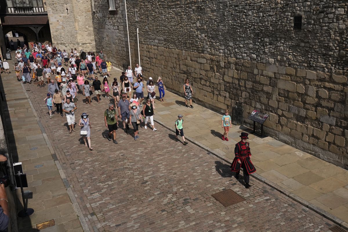 On what some have called "Freedom Day", marking the end of coronavirus restrictions in England, visitors follow as Yeoman Warder Barney Chandler leads the first tour of the Tower of London in 16 months since the start of the coronavirus outbreak, in London, Monday, July 19, 2021. Beginning Monday, face masks will no longer be legally required and with social distancing rules shelved, but mask rules will remain for passengers on the London transport network. (Matt Dunham)