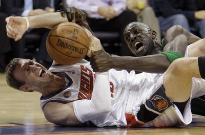 Boston’s Kevin Garnett, right, tries to grab the ball from Charlotte’s Matt Carroll during the second half of the Bobcats’ overtime victory Tuesday. (Associated Press / The Spokesman-Review)