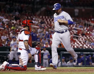 Dodgers’ Adrian Gonzalez, right, scores past St. Louis Cardinals catcher Yadier Molina in Tuesday’s game. (Jeff Roberson / Associated Press)