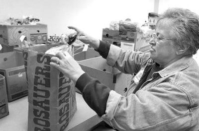 
Deloris Christopher packs a bag of food at the Spokane Valley Food Bank. Christopher  has been volunteering at the food bank for eight years. 
 (J. BART RAYNIAK / The Spokesman-Review)