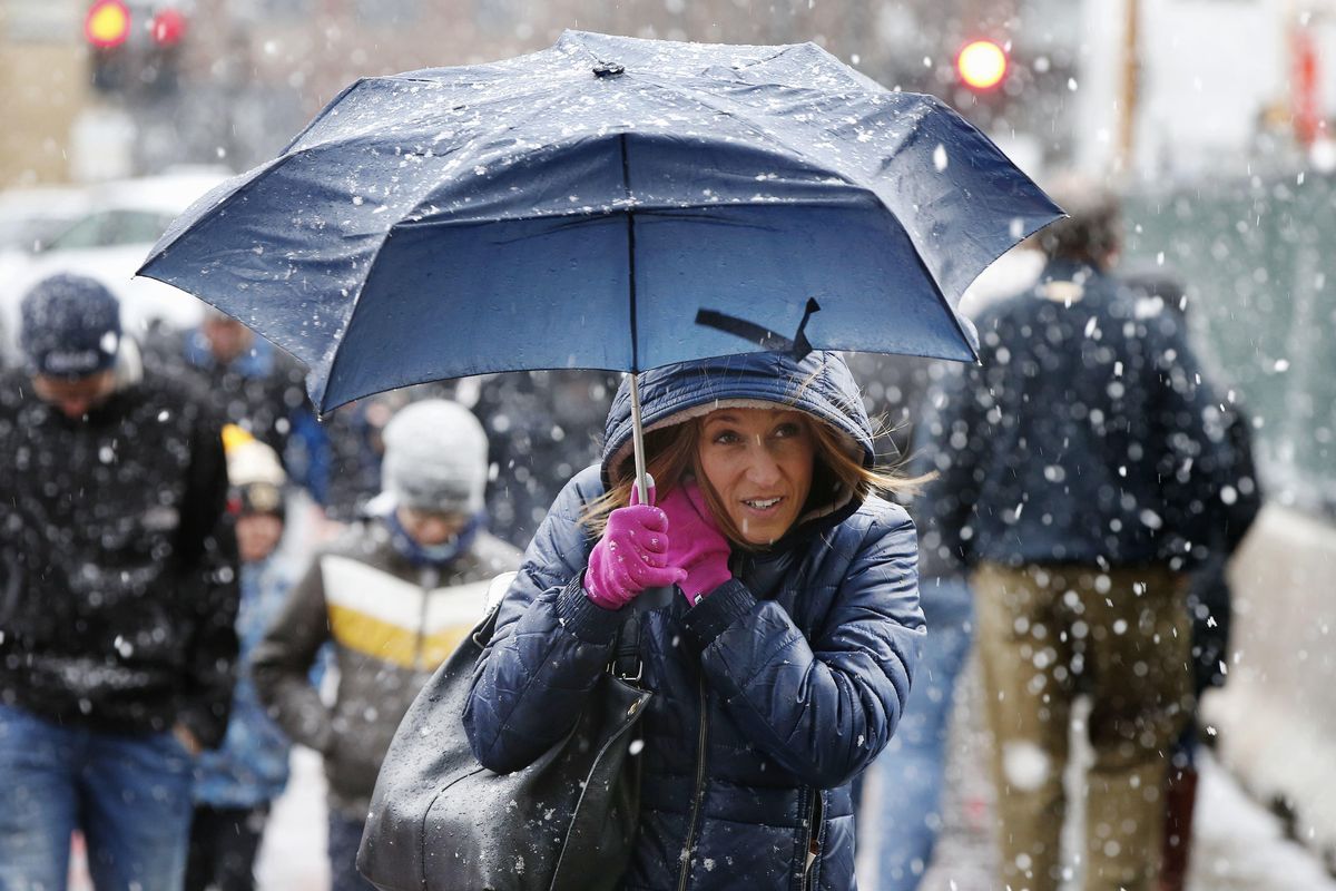 A woman walks with an umbrella as snow falls in Boston, . The April Fools Day storm that brought heavy, wet snow to much of northern New England is winding down, but not before causing crashes on highways across the region and leaving thousands without power. (Michael Dwyer / Associated Press)