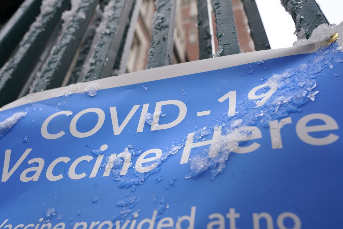 A sign covered with ice advertises a COVID-19 vaccination site in New York, Tuesday, Feb. 2, 2021. The site was closed today due to the inclement weather. Coronavirus vaccination sites across the Northeastern U.S. are getting back up and running after a two-day snowstorm that also shut down public transport, closed schools and canceled flights. Some vaccination sites in New York City remained closed, but others, including those run by the public hospital system, were open Tuesday. (Seth Wenig)