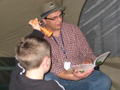Central Valley Superintendent Ben Small reads by flashlight in a tent in the gymnasium during the Adventures in Reading event, Camp Progress, at Progress Elementary last month. Photo courtesy of Central Valley School District (Photo courtesy of Central Valley School District / The Spokesman-Review)