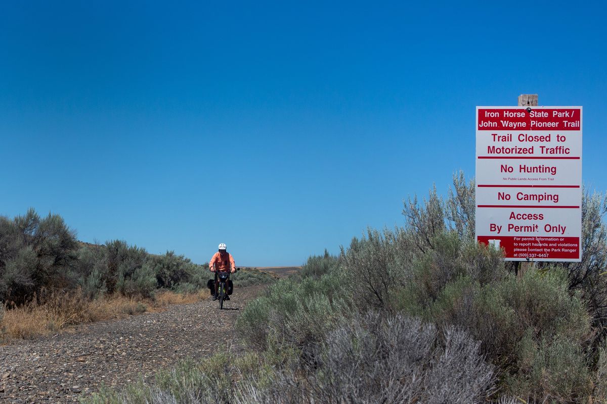 Larry Cebula, a professor of history at Eastern Washington University, e-bikes along the Palouse-to-Cascades trail near Lind, Wash. on July 11, 2022.  (Eli Francovich)