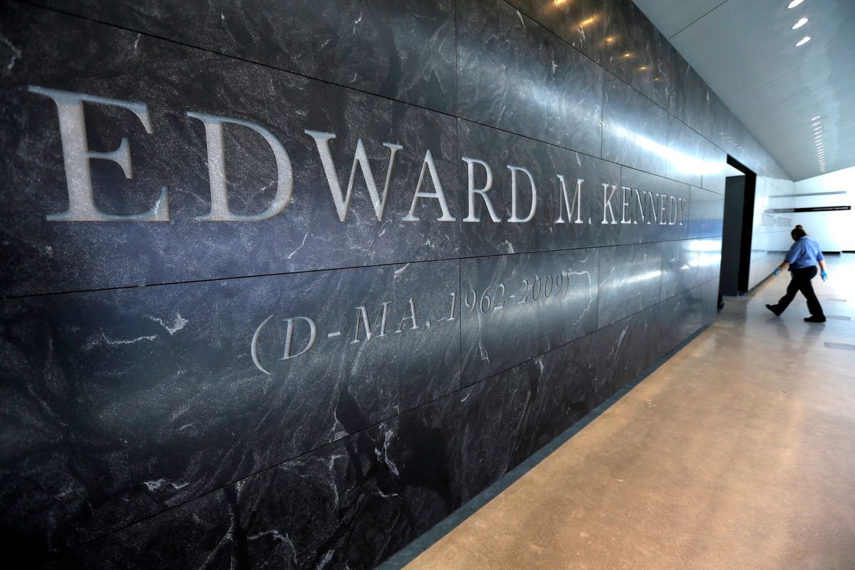 A passer-by walks near the engraved name of the late U.S. Sen. Edward M. Kennedy near the main entrance to the Edward M. Kennedy Institute, in Boston, March 23, 2015. An Associated Press review finds state and local governments have spent nearly $1 billion worth of federal coronavirus aid on projects that have little to do with combating the pandemic. Lawmakers delivered $5 million to pay off debts of the Edward M. Kennedy Institute for the U.S. Senate, a nonprofit established to honor the senator that has struggled financially.  (Steven Senne)