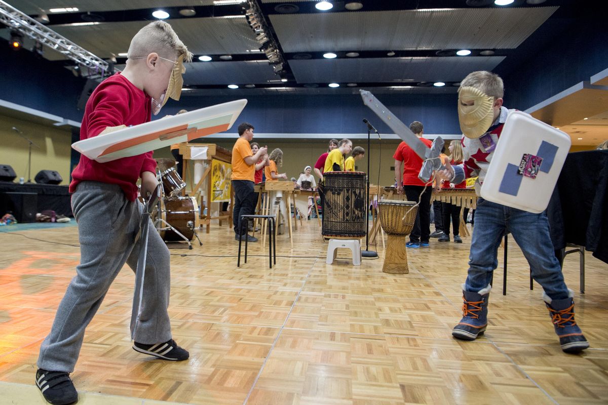 After crafting their own swords and shields at the craft tables, Payton Slick, 5, left, and Myles Neal, 6, right, square off while the Musha Marimba group plays in the background Sunday, Dec. 31, 2017, at the Spokane Convention Center ballrooms. It was the start of First Night’s Kids Night Out events in Spokane. The First Night events continued into the evening with both family and adults-only events. (Jesse Tinsley / The Spokesman-Review)