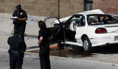 
Los Angeles police investigate an accident on the 110 freeway, north of the 91 Freeway, April 13, in Los Angeles. The driver crashed into the freeway retaining wall after being shot, according to authorities. 
 (AP photo/Los Angeles Times, Bob Chamberlain / The Spokesman-Review)