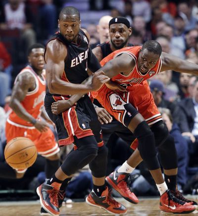 Chicago’s Luol Deng, right, knocks ball away from Dwyane Wade. (Associated Press)