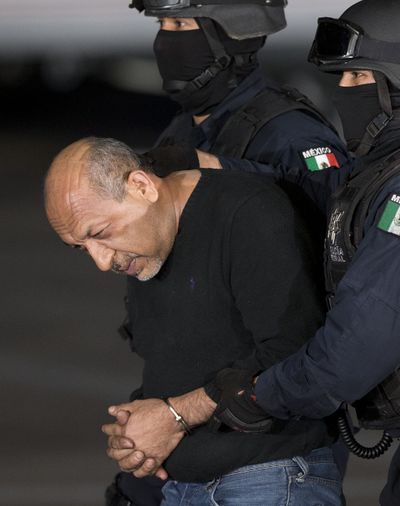 Federal police escort Servando “La Tuta” Gomez, leader of the Knights Templar cartel, Friday in Mexico City. (Associated Press)