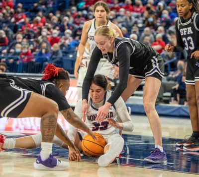 Gonzaga's Melody Kempton (33) loses the handle on the ball and is swarmed by Stephan F. Austin's Zya Nugent (22), left, and Stephanie Visscher, right, in their non-conference matchup Sunday, Dec. 12, 2021 at the McCarthey Athletic Center at Gonzaga University in Spokane, Washington.  (Jesse Tinsley/The Spokesman-Review)