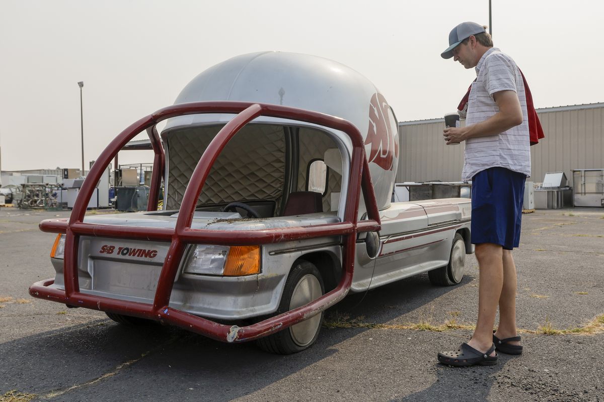 A shopper looks at an electric vehicle that Washington State University’s Surplus Sales sold in an online auction on Friday in Pullman. The vehicle was previously used by the WSU Athletic Department. (Geoff Crimmins/For The Spokesman-Review)