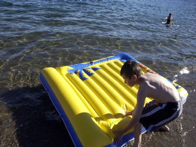 
Devon Kampen, 12, pushes a raft off a private section of Sanders Beach on Tuesday afternoon. 
 (Jesse Tinsley / The Spokesman-Review)