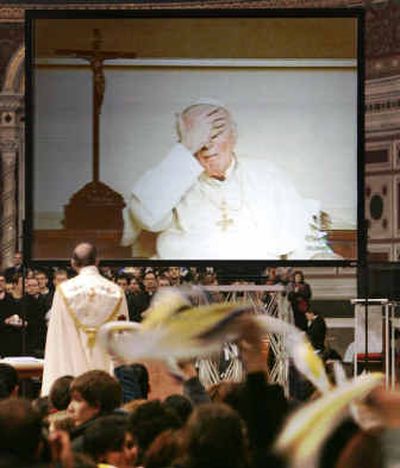 
Pope John Paul II touches his forehead during a live video link Thursday to hundreds of young people who filled Rome's St. John at the Lateran Basilica in Rome for a meeting. 
 (Associated Press / The Spokesman-Review)