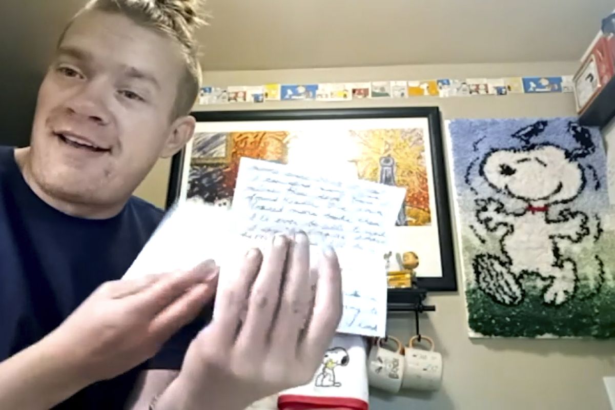 In this Dec. 20, 2020, still image taken from video, Wesley Morgan, a 32-year-old in Denver, shows a letter from one of his “Peanuts” pen pals. After being furloughed from his job at the Denver International Airport, Morgan began writing to over 500 older adults living in isolation due to the pandemic. He says 142 responded, and many have become consistent correspondents.  (Jessie Wardarski)