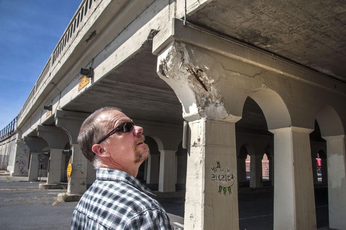Spokane Riverkeeper Jerry White Jr. inspects the damage on a railroad bridge on Cedar Street near First Avenue in downtown Spokane. (Dan Pelle / The Spokesman-Review)