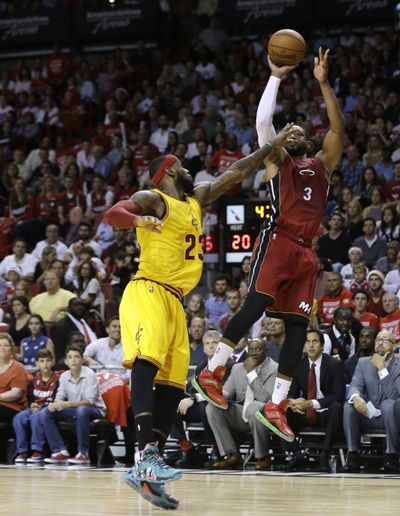 Heat’s Dwyane Wade shoots over pal and ex-teammate LeBron James of Cavaliers. (Associated Press)