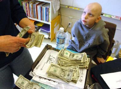 
Fifth-grader Dylan Corbin watches his teacher, Kathy Zinkgraf, count money from a fundraiser at Freeman Elementary School on March 3. Dylan has leukemia, and the children at his school and Freeman Middle School wanted to help his family. 
 (Jesse Tinsley / The Spokesman-Review)