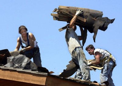 
From left, JyJy Jones, Chad Charvat and Greg McKee tear shake roofing off a house on Woodruff in the Ponderosa neighborhood in Spokane Valley on Tuesday, as the temperature climbed to the upper 90s. 
 (Liz Kishimoto / The Spokesman-Review)
