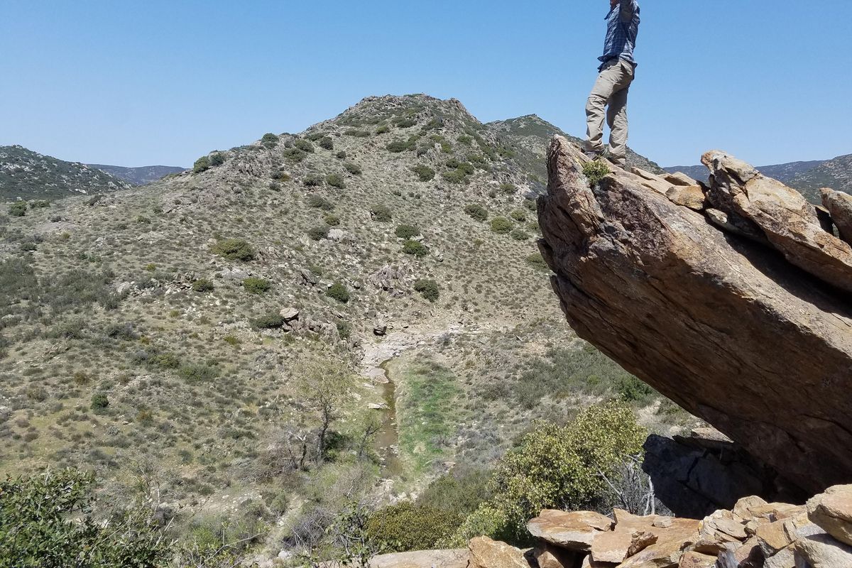 Nick DeLangis stands on the edge of rock in the desert while hiking the Pacific Crest Trail this summer. (Tiahnna Willms / Courtesy)
